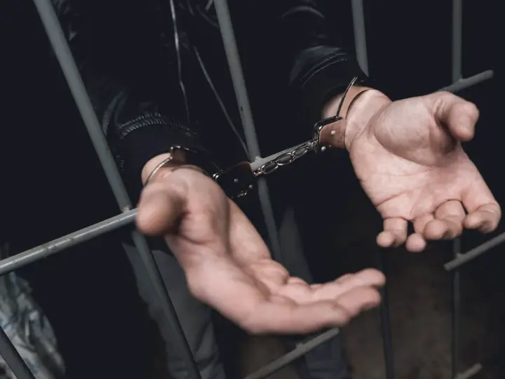 Ręce w kajdankach za kratami. Historia o tym, kiedy policja ściga za alimenty, kończy się zatrzymaniem.