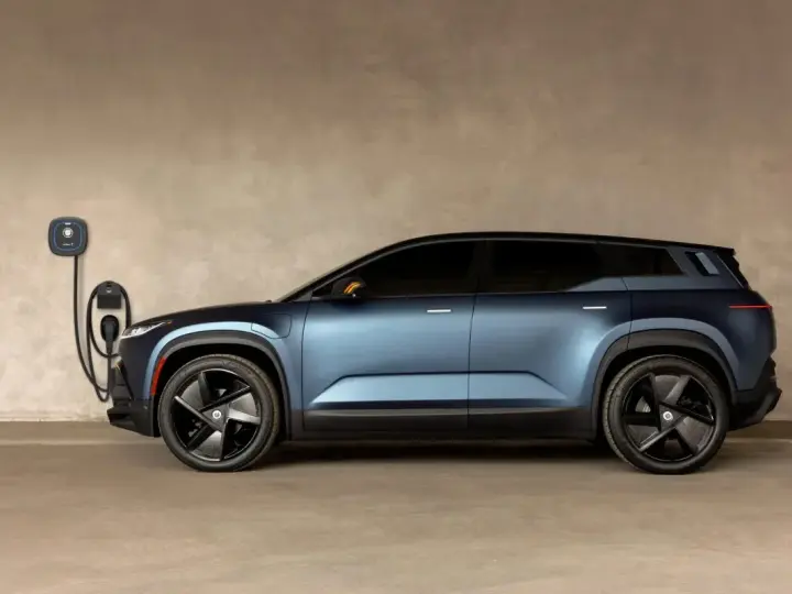 Niebieski Fisker Ocean zaparkowany przy ładowarce ściennej.