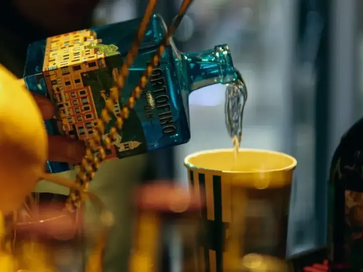 Barmistrz nalewa gin z butelki Portofino do szklanki, przygotowując drinka. Ciekawi Cię, jak smakuje martini?