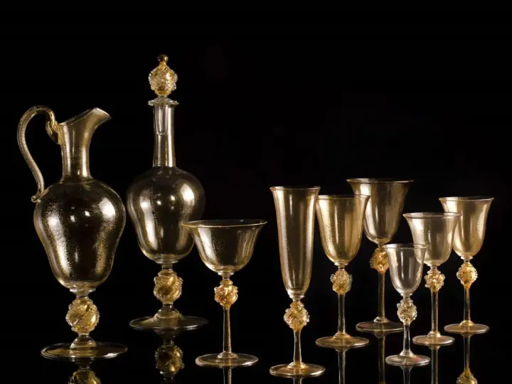 Servizio in vetro di Murano dorato, con decorazioni a foglia d'oro. La maestria nella lavorazione del vetro, che richiede un'accurata gestione della temperatura fusione vetro Murano, crea questi capolavori.