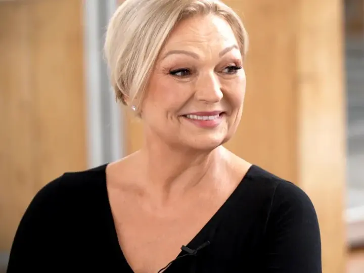 Uśmiechnięta Małgorzata Walewska, której wiek dodaje jej uroku, w czarnej bluzce.