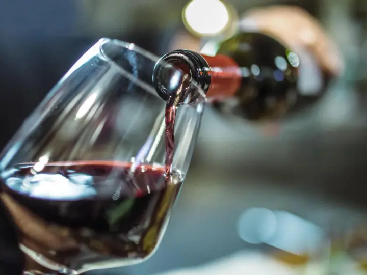 Rotwein fließt ins Glas. Ein Schluck für die Gesundheit und den Genuss.