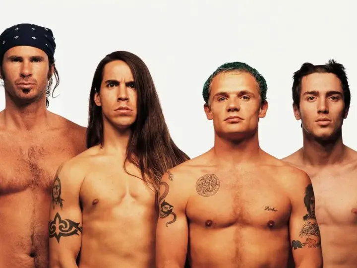 Les membres des Red Hot Chili Peppers, torse nu, posent pour une photo. L'âge ne semble pas avoir d'emprise sur leur énergie.