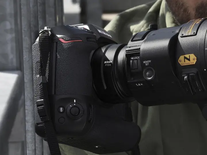 Profesjonalny aparat Nikon z obiektywem i adapterem FTZ II gotowy do akcji.
