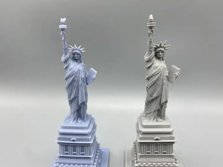 Two Statue of Liberty models: one smooth, likely resin vs. filament 3d printer with visible layer lines.