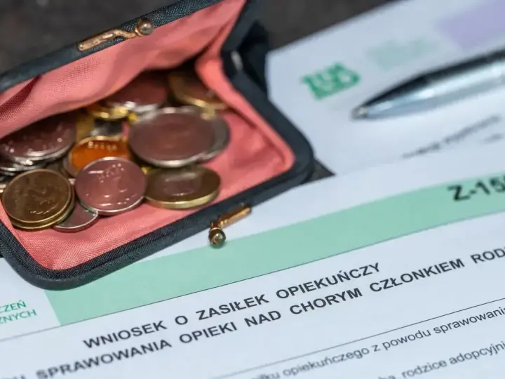 Portmonetka z monetami leży obok formularza ZUS Z-15B, który dotyczy wniosku o zasiłek opiekuńczy.