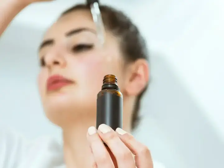 Kobieta aplikuje serum na twarz. Odkryj zachwycające ozonowanie twarzy efekty dla promiennej cery.