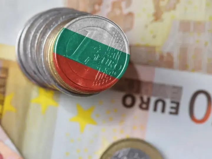 Monety z flagą Bułgarii leżą na banknotach euro. Waluta Bułgarii, lew, obok euro.