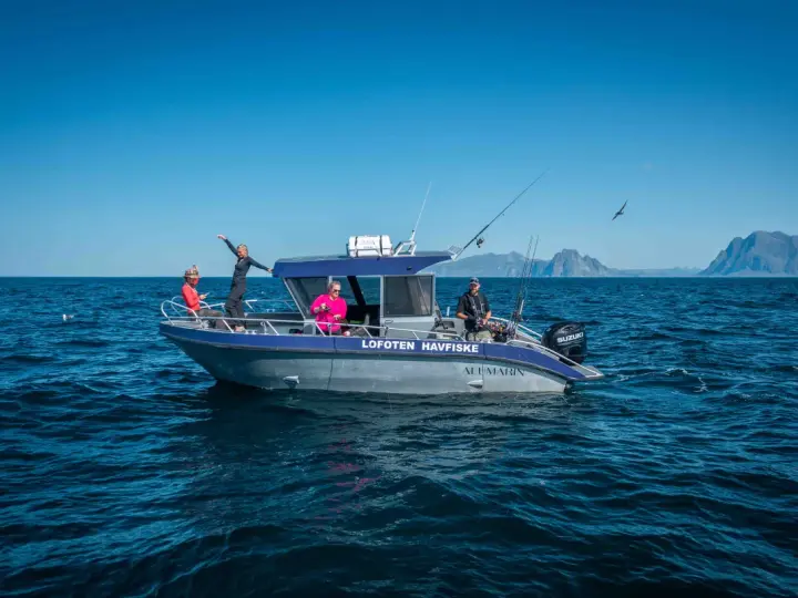 Fisketur i Nordnorge med båten "Lofoten Havfiske". Soligt och blåsigt, med berg i bakgrunden.