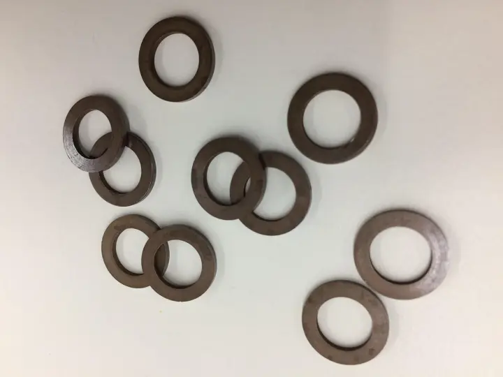 Un gruppo di rondelle alzaporta marroni, usate per regolare l'altezza delle porte.
