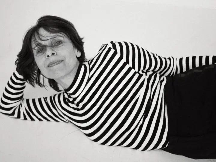 Katarzyna Krzanowska w czarno-białym swetrze w paski, leżąca na boku, z ręką pod głową.