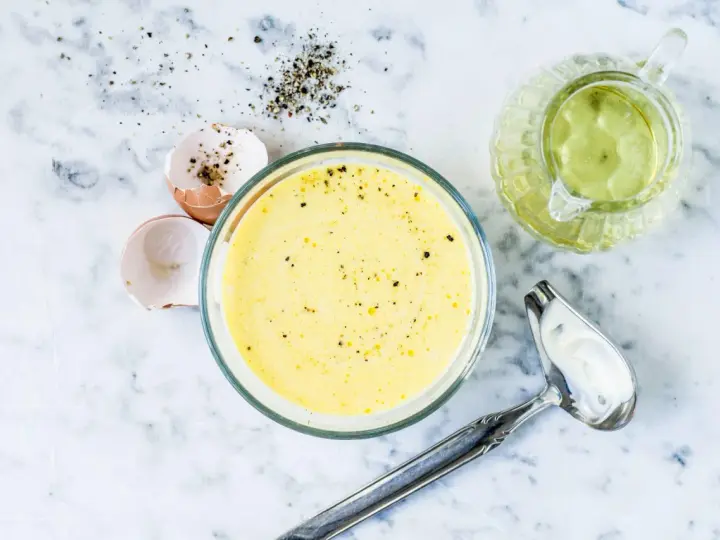 Zutaten für eine cremige french dressing: Eierschalen, Pfeffer, Öl und eine Schüssel mit der fertigen Soße.