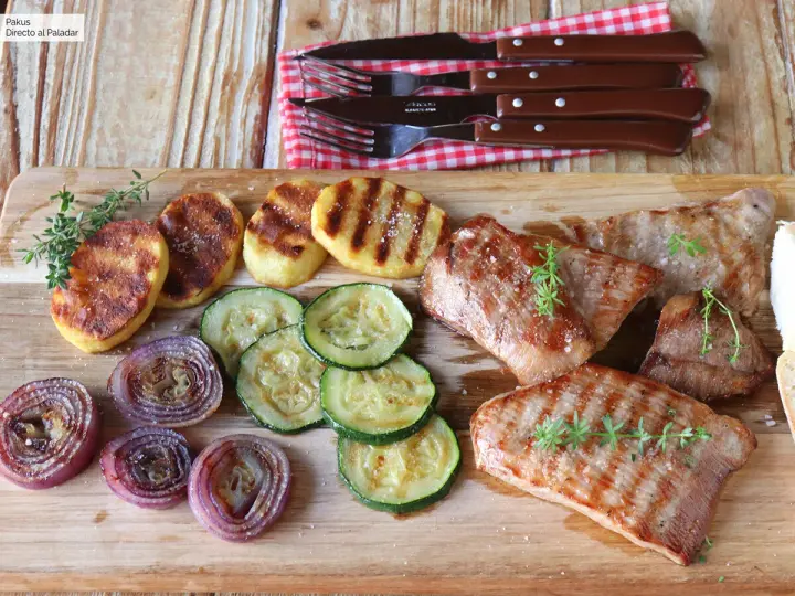 Delicioso escalope de ternera a la parrilla con patatas, calabacín y cebolla morada.