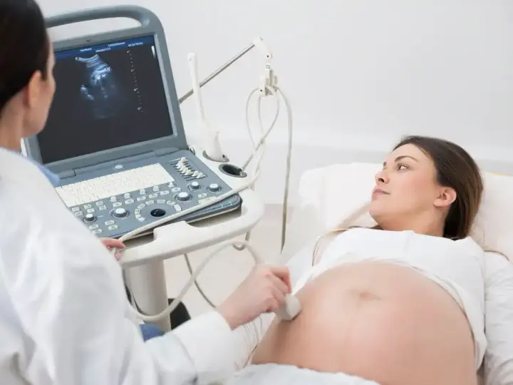 Lekarz wykonuje badanie USG, sprawdzając obrót zewnętrzny płodu u ciężarnej kobiety.