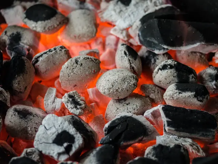 Żarzące się węgle, idealne do grillowania. Pamiętaj, że do kiedy można palić węglem, zależy od lokalnych przepisów i sezonu grzewczego.