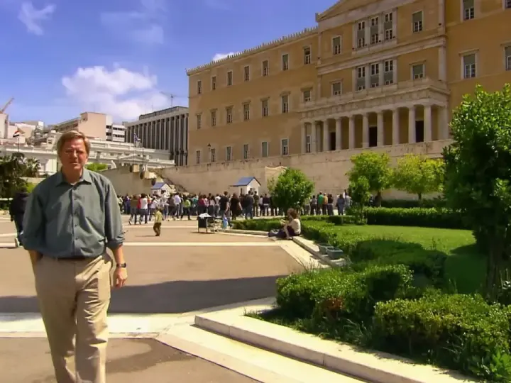 Rick Steves explores Athens, standing before the Hellenic Parliament building with a crowd gathered for the changing of the guard.