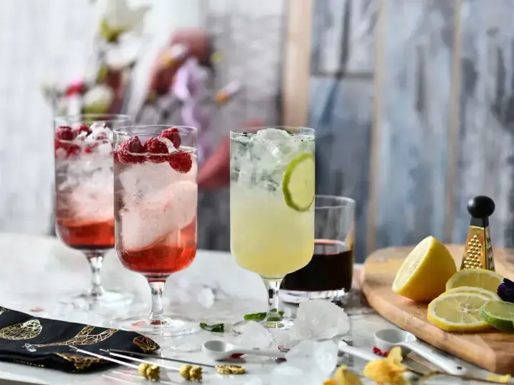 Orzeźwiający drink w shakerze z malinami i limonką, idealny na letnie popołudnie.