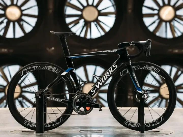 A black S-Works aero bike, designed for speed, is showcased in front of large industrial fans. This is what an aero bike looks like.