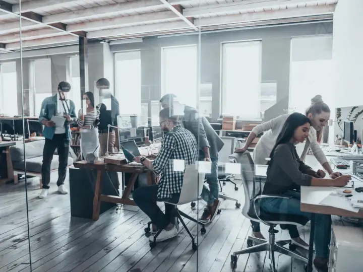 Persone lavorano in un ufficio moderno, un esempio di coworking cos'è: collaborazione e flessibilità in un ambiente dinamico.