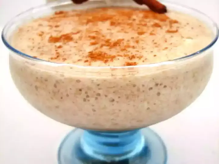 Un déliceux mousse banane crémeuse, saupoudrée de cannelle, servie dans un joli bol en verre bleu.
