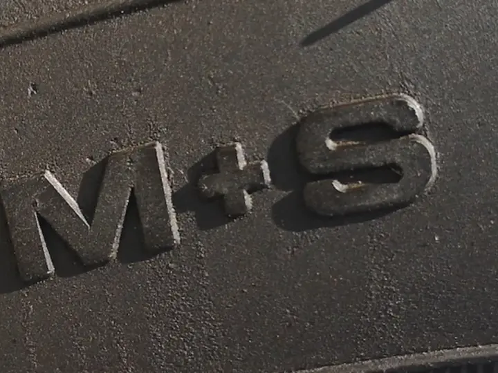 Napis "M+S" na bieżniku opony, oznaczający gotowość na błoto i śnieg.