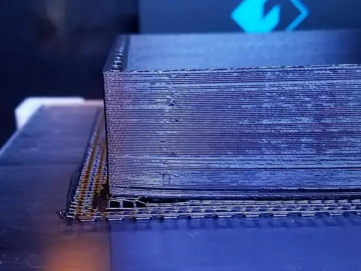 Drukarka 3D tworzy obiekt z czarnego materiału PEEK, warstwa po warstwie.