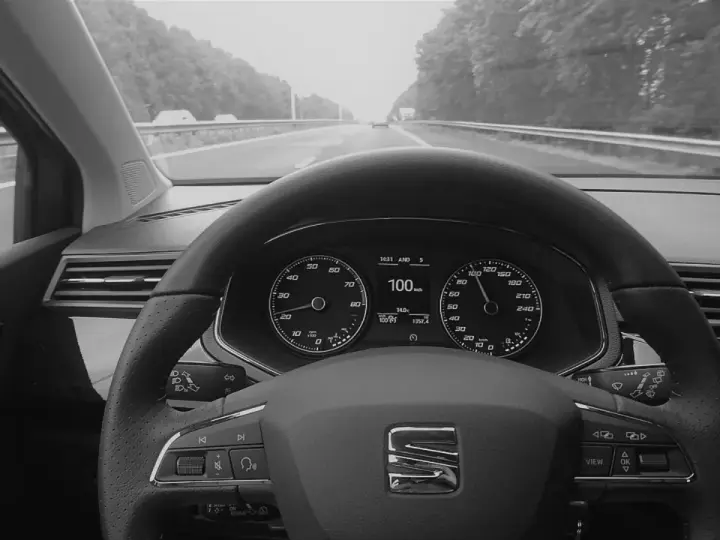 Blick auf das Armaturenbrett eines Autos mit aktiviertem Tempomat. Der Tacho zeigt 100 km/h.