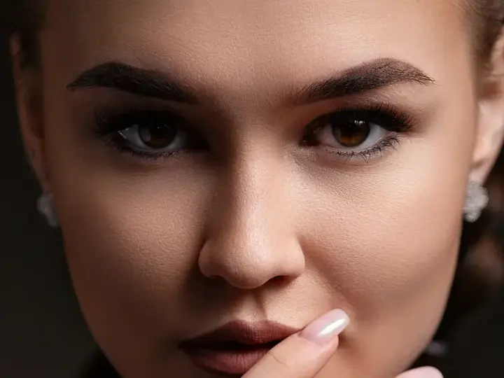 Un gros plan sur le visage d'une femme, ses sourcils parfaitement dessinés après une séance d'épilation.