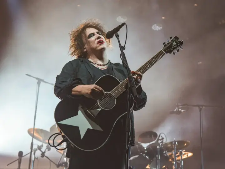 Robert Smith von The Cure spielt auf einer Gitarre mit weißem Stern.
