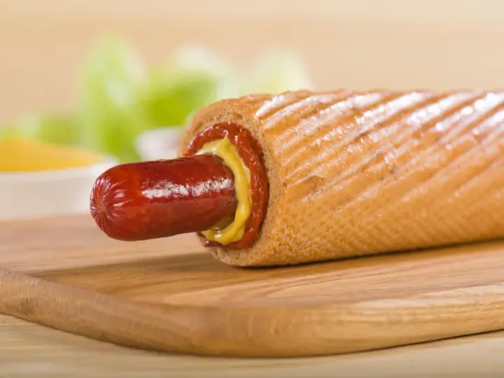 Pyszne hot dogi domowe z musztardą i ketchupem na desce.