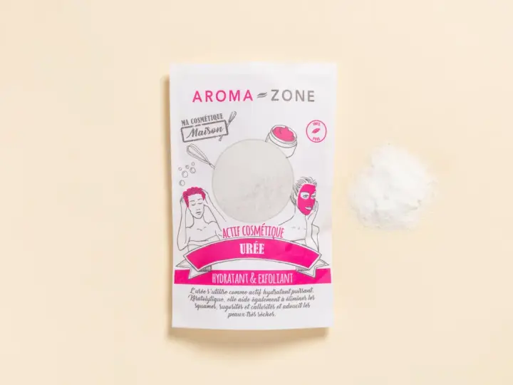 Un sachet d'actif cosmétique "Urée" d'Aroma-Zone, idéal pour hydrater et exfolier, avec une poudre blanche à côté.
