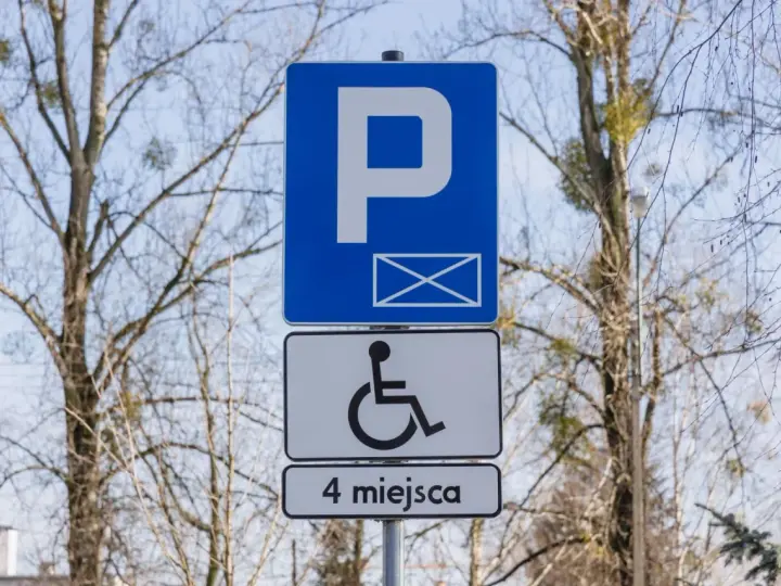 Znak informuje o parkingu dla osób z niepełnosprawnościami. Orzeczenie o niepełnosprawności można uzyskać na wiele chorób, np. schorzenia narządu ruchu.