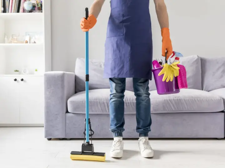 Prêt à laver par terre avec une serpillère et un seau rempli de produits de nettoyage.