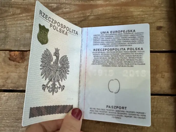 Otwarty polski paszport z godłem orła i tekstem w językach Unii Europejskiej.