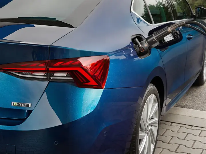 Rifornimento di un'auto blu con motore a metano. La pompa è inserita nel serbatoio.