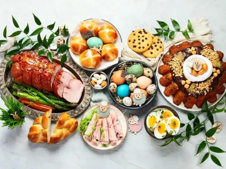 Wielkanocny stół pełen pyszności: pieczony schab, babka, pasztety, jajka, bułeczki i inne przekąski na wielkanoc.