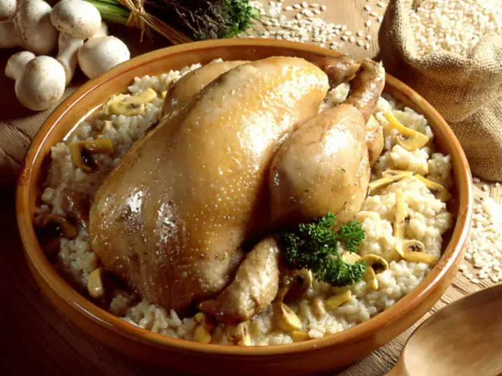 Un plat réconfortant de poule au riz crémeux, garni de champignons et d'une touche de persil frais.