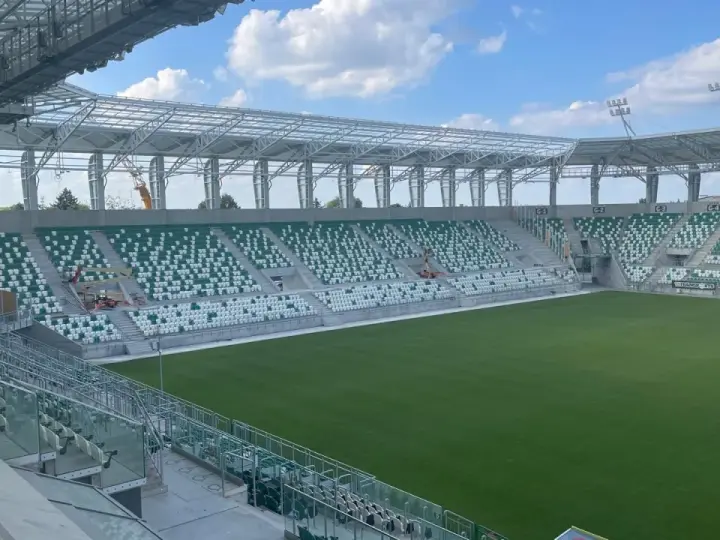 Puste sektory stadionu Radomiaka czekają na kibiców. Zielona murawa i nowoczesna konstrukcja dachu tworzą imponujący widok.