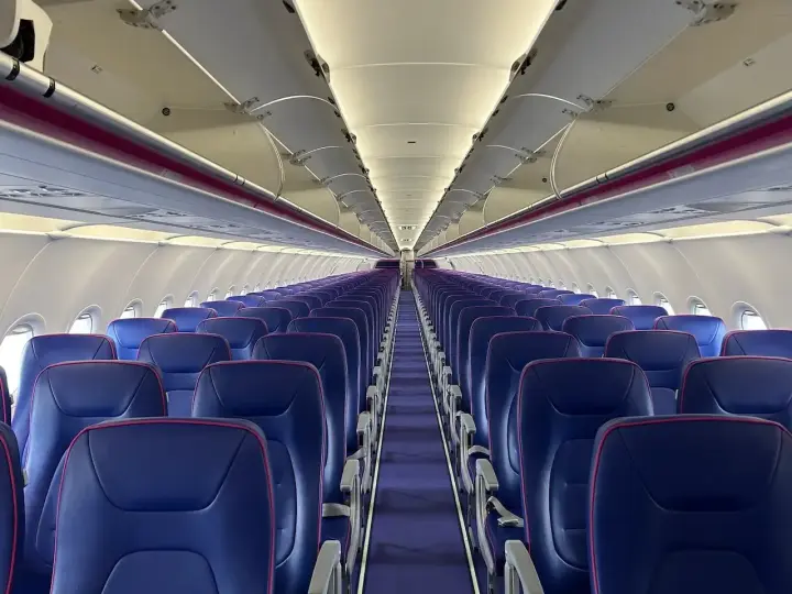 Puste fioletowe siedzenia w samolocie Wizz Air.