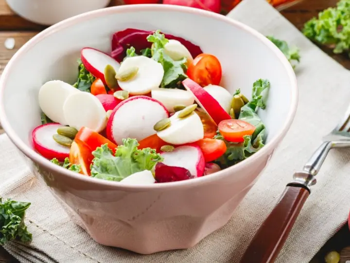 Świeża sałatka do grilla w 3 minuty: rzodkiewka, pomidorki, ser mozzarella i pestki dyni w misce.