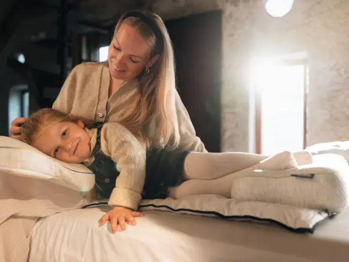 Mutter streichelt Kind, das auf einem Kissen liegt. Gute Nacht-Tipps für Kinder 11 Jahre.