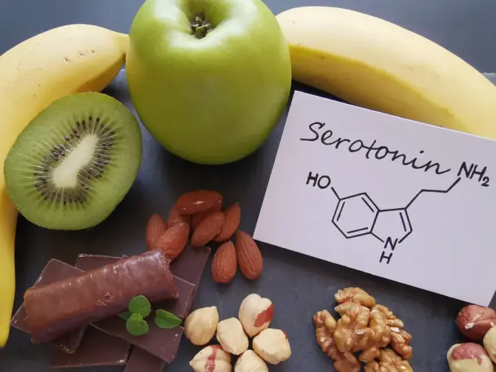 Banany, kiwi, jabłko, czekolada i orzechy. Na kartce wzór chemiczny serotoniny. W czym jest serotonina? W tych produktach!