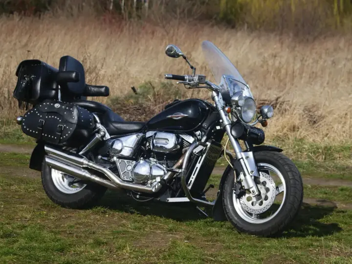 Czarny Suzuki Marauder z sakwami i oparciem, gotowy na podróż przez jesienne krajobrazy.