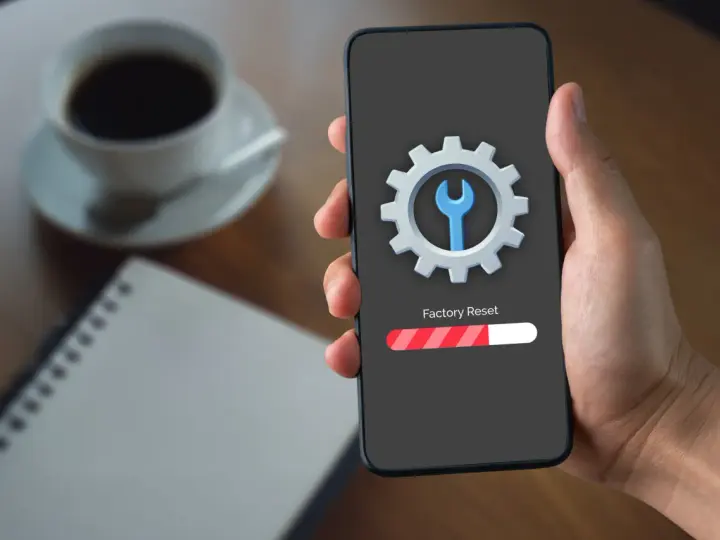 Telefon z ikoną narzędzi i paskiem postępu "Factory Reset". To może pomóc, gdy chcesz naprawić dotyk w telefonie.
