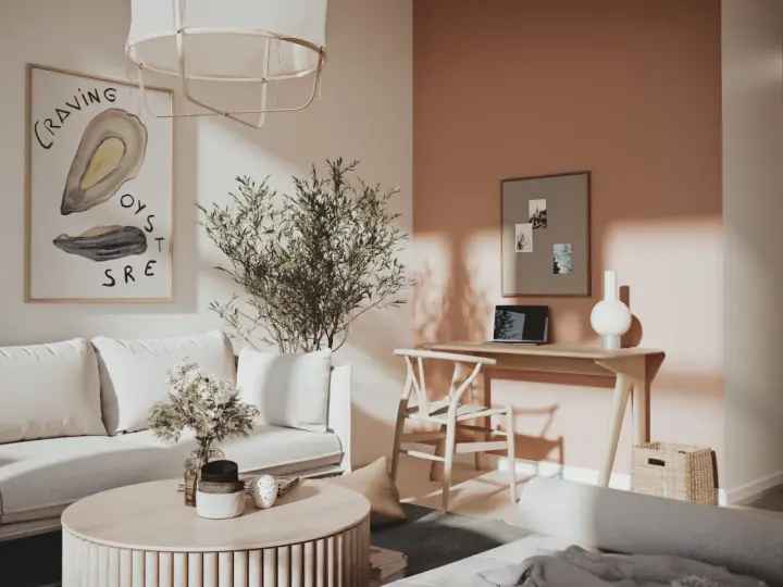Ett inrett litet rum med en bekväm soffa, ett runt soffbord med blommor och en arbetsplats vid ett fönster.