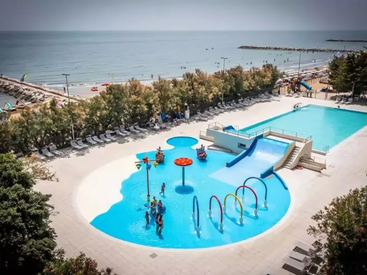 Rodzinna zabawa w wodnym świecie przy plaży w San Francesco Caorle: baseny, zjeżdżalnie i brodziki dla dzieci.