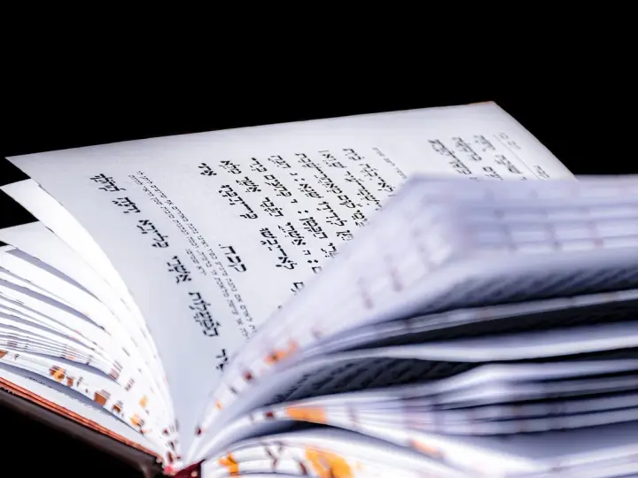 Otwarta księga z tekstem w języku hebrajskim, widoczny psalm 27 tekst.