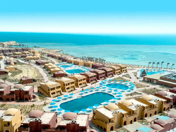 Widok z lotu ptaka na kompleks hotelowy Pickalbatros Marsa Alam z basenami i budynkami w stylu orientalnym, w tle turkusowe Morze Czerwone.