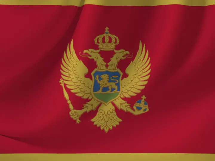 Flaga Czarnogóry z dwugłowym orłem. W tym kraju obowiązuje euro, a język urzędowy to czarnogórski.
