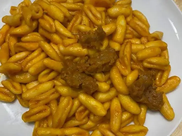 Un piatto invitante di gnocchetti alla campidanese, conditi con un sugo ricco e pezzetti di carne saporita.